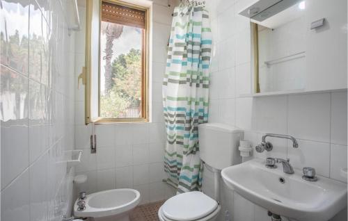 baño con aseo y lavabo y ventana en 3 Bedroom Nice Home In St, Maria Del Focallo, en Santa Maria del Focallo