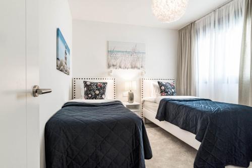 1 dormitorio con 2 camas y ventana en INF46P - Infinity Estepona by Roomservices, en Estepona