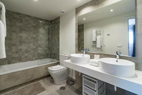 y baño con 2 lavabos, bañera y aseo. en INF46P - Infinity Estepona by Roomservices, en Estepona
