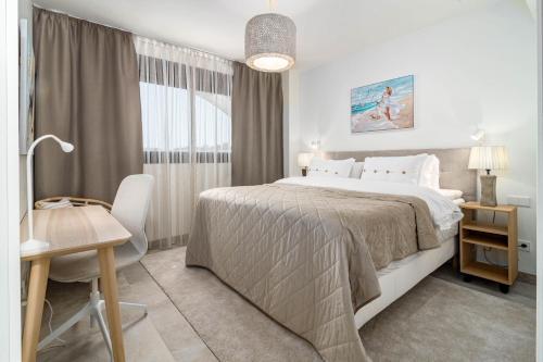 ein Schlafzimmer mit einem Bett, einem Tisch und einem Schreibtisch in der Unterkunft INF26H- Comfortable and spacious city apartment in Estepona