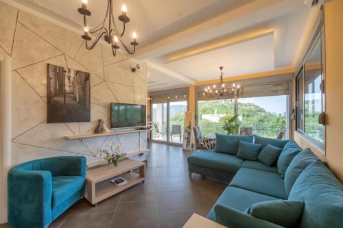 a living room with a blue couch and a tv at Villa Montenegrina in Petrovac na Moru