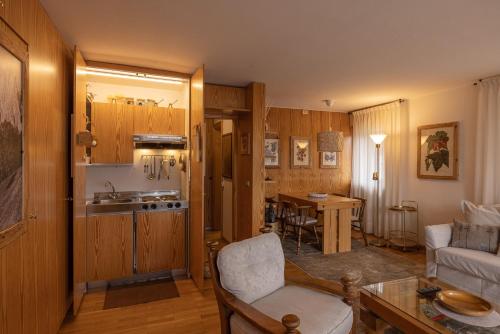 cocina y sala de estar con sofá y mesa en Sorapis Mini - Monolocale Panoramico, en Cortina dʼAmpezzo