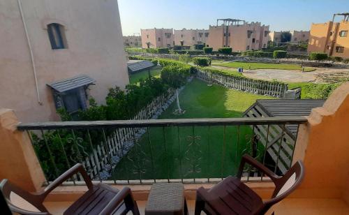a balcony with chairs and a view of a river at La Hacienda Ras Sudr Two Bedroom Chalet Ras Matarma in Ras Sedr