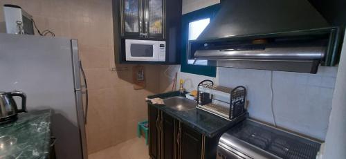 a small kitchen with a sink and a microwave at La Hacienda ras sedr chalet in Ras Sedr