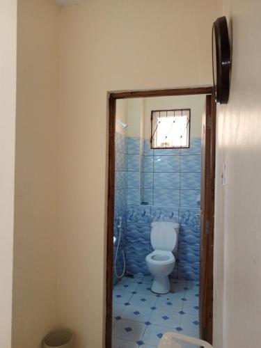 La salle de bains est pourvue de toilettes et d'une fenêtre. dans l'établissement YellowMellow, à Kilifi