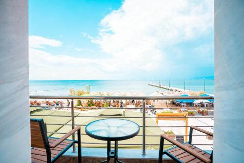 a balcony with a table and chairs and the beach at Casa la Scala in Agia Triada