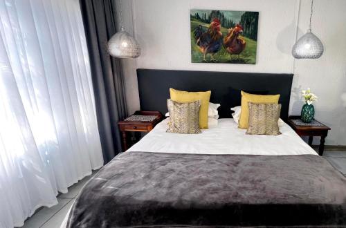 a bedroom with a large bed with yellow pillows at Rabbit Hole Hotel in Krugersdorp