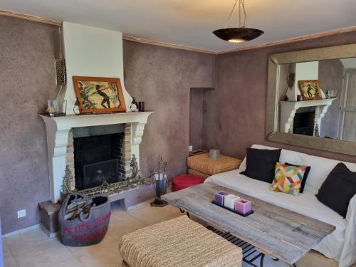 a living room with a fireplace and a couch at Mas de la Petite Jeanne in Grimaud