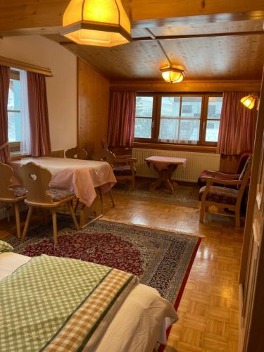 een woonkamer met 2 bedden en een tapijt bij Appartements Pension Elfi in Gosau