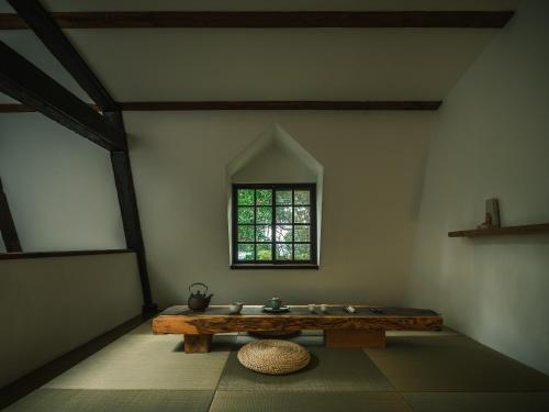 a room with a wooden table and a window at Deep Breath B&B in Fengshan
