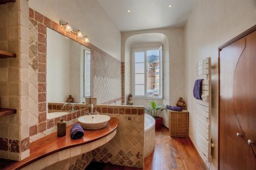 une salle de bain avec un lavabo, une baignoire et un miroir dans l'établissement Casa Marina, à Bastia