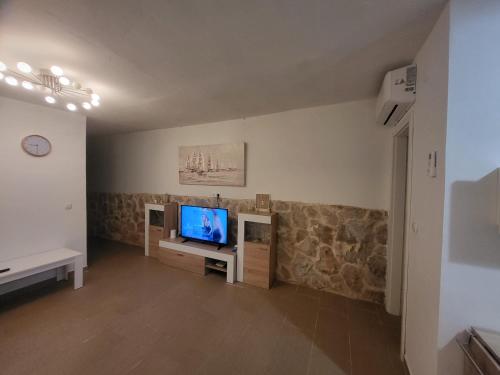 een woonkamer met een televisie en een bank bij Kuća za odmor Zip in Murter