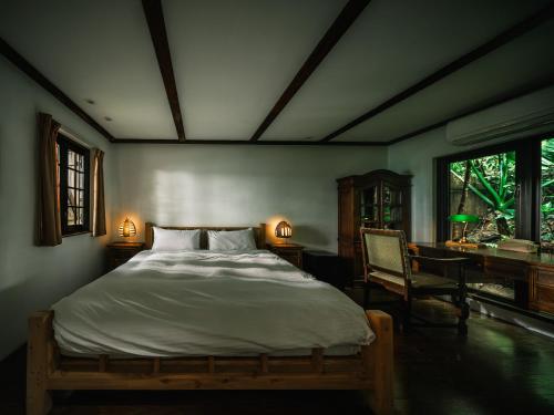 1 dormitorio con 1 cama, escritorio y ventanas en Deep Breath B&B en Fengshan