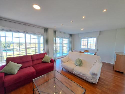 a living room with a red couch and a glass table at Samil, Vigo, chalet con finca in Vigo