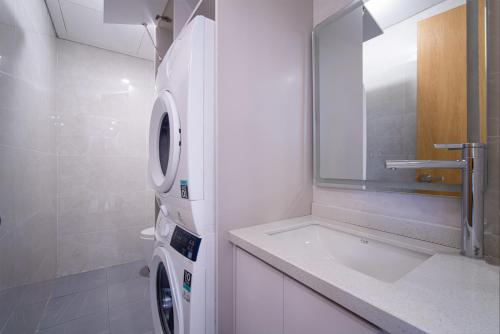 a bathroom with a washing machine and a sink at HSuites Riverside Hotel and Apartment in Da Nang
