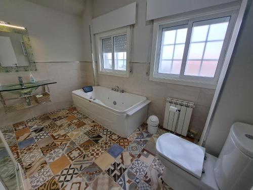 een badkamer met een bad, een toilet en een wastafel bij Samil, Vigo, chalet con finca in Vigo