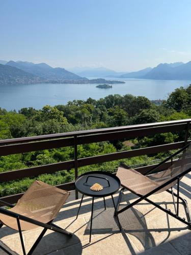 uma mesa e cadeiras numa varanda com vista para um lago em Panorama em Someraro