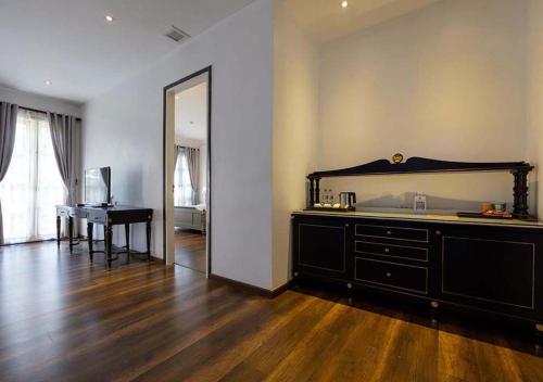 a room with a bed and a desk and a mirror at Le Thatluang D'oR Boutique Hotel in Vientiane