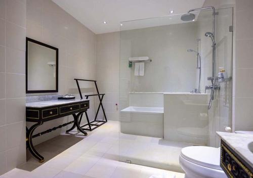 a bathroom with a tub and a sink and a toilet at Le Thatluang D'oR Boutique Hotel in Vientiane