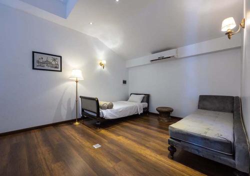 a room with a bed and a couch in it at Le Thatluang D'oR Boutique Hotel in Vientiane