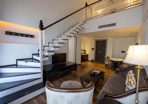 a living room with a spiral staircase in a house at Le Thatluang D'oR Boutique Hotel in Vientiane