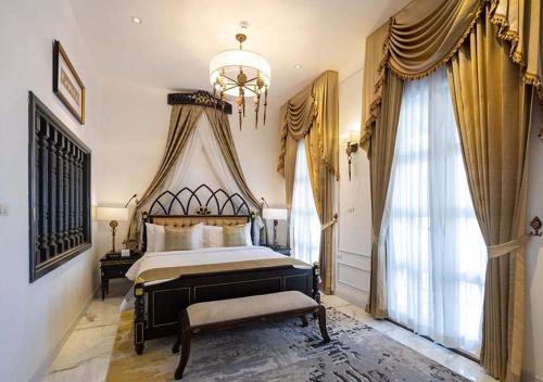 a bedroom with a large bed and a chandelier at Le Thatluang D'oR Boutique Hotel in Vientiane