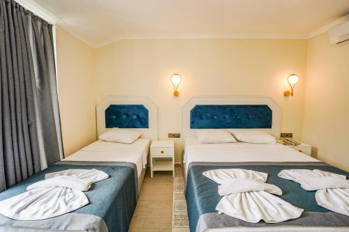 a hotel room with two beds and a window at Blue Pearl Hotel in Ovacik