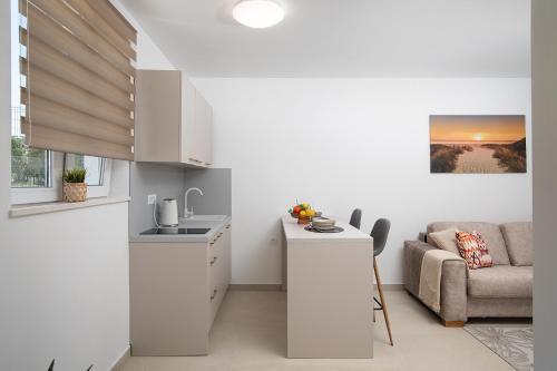 a kitchen and living room with a couch and a table at Apartments and rooms Jakić in Medulin