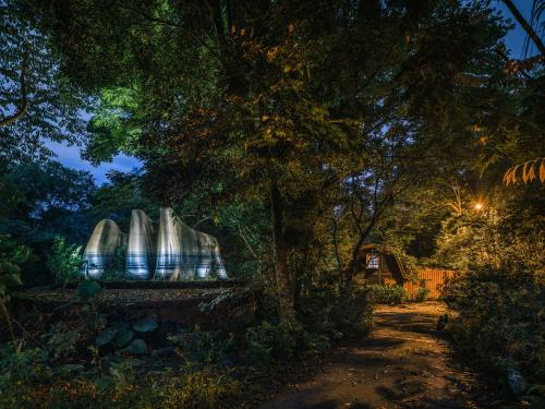 a bench under a tree in a forest at night at Deep Breath B&B in Fengshan