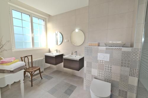 Baño con 2 lavabos y espejo en Manoir de Kerguestenen en Gestel