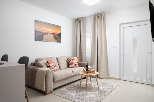 a living room with a couch and a table at Apartments and rooms Jakić in Medulin