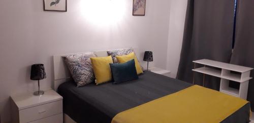 um quarto com uma cama com almofadas coloridas em Apartamento T1 - Orlamar em Vila Nova de Cacela