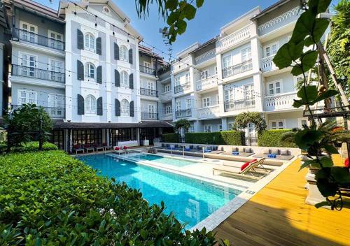 a hotel with a swimming pool in front of a building at Le Thatluang D'oR Boutique Hotel in Vientiane