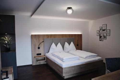 a bedroom with a large bed with white pillows at Das Joes Frühstückspension 