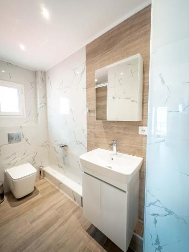 a white bathroom with a sink and a toilet at Casa la Scala in Agia Triada