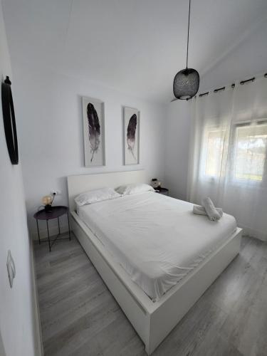 Un dormitorio blanco con una gran cama blanca. en Villa yoli 26 chalet con piscina cerca de la playa en Chiclana de la Frontera