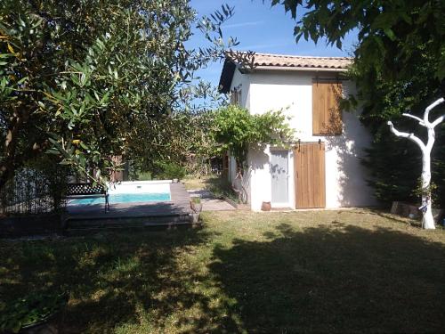 a house with a swimming pool in a yard at La Maison du Béchon in Blanquefort