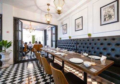 a dining room with a long table and chairs at Le Thatluang D'oR Boutique Hotel in Vientiane