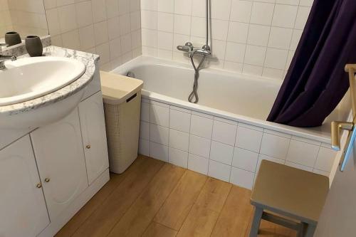 La salle de bains est pourvue d'un lavabo et d'une baignoire avec lavabo. dans l'établissement A 2 min des plages Clim parking, à Sainte-Maxime