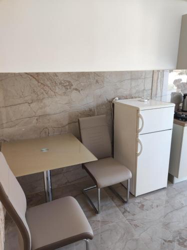 a kitchen with a table and chairs and a refrigerator at Apartments Katica in Metajna