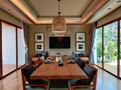 a dining room with a large wooden table and chairs at Rarin Villas in Chiang Mai