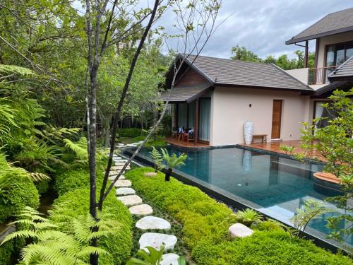 a swimming pool in front of a house at Rarin Villas in Chiang Mai