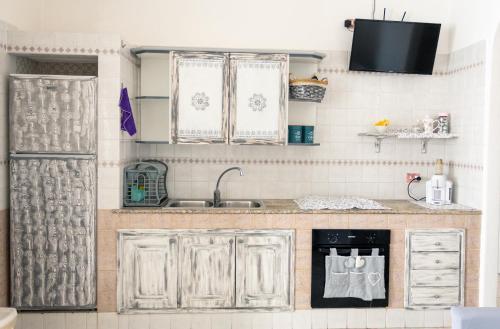 eine Küche mit weißen Schränken und einem Waschbecken in der Unterkunft Dimora Di Meglio a un passo dal mare in Ischia