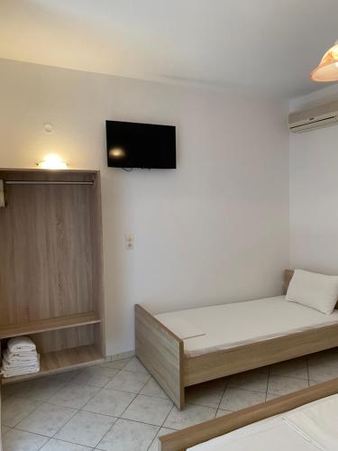 a room with a bed and a tv on the wall at Villa Elva in Ammoudia