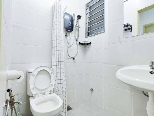 a white bathroom with a toilet and a sink at Hygge Living Kampar (Near UTAR) in Kampar