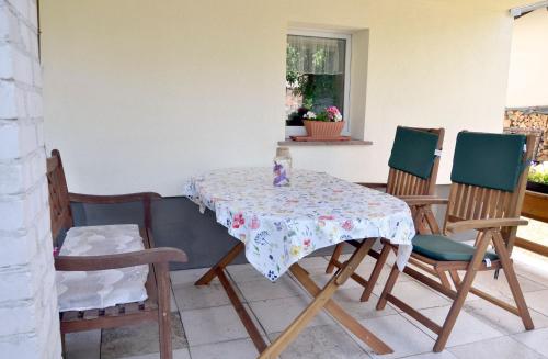a table with four chairs and a table with a table cloth at Ferienwohnung zum Bären 