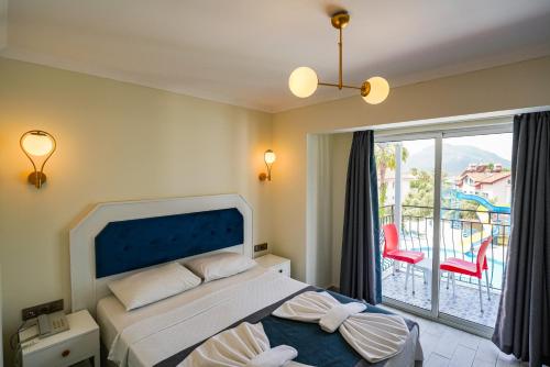a bedroom with a bed and a balcony at Blue Pearl Hotel in Ovacik