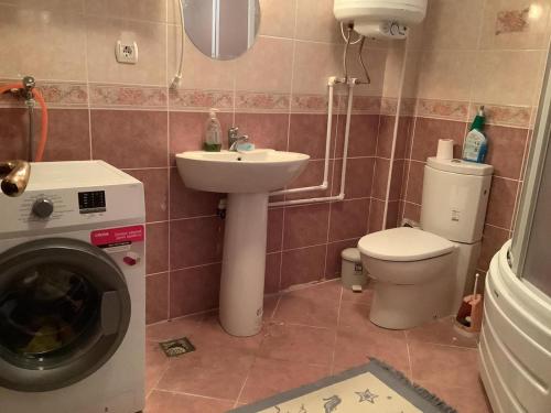 y baño con aseo, lavabo y lavadora. en Cozy and Spacious Villa, en Golbası