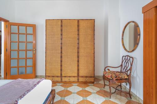 a bedroom with a bed and a mirror and a chair at Villa Aurora in Vico Equense