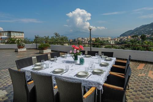 a table with plates and glasses and flowers on a balcony at Villa Aurora in Vico Equense